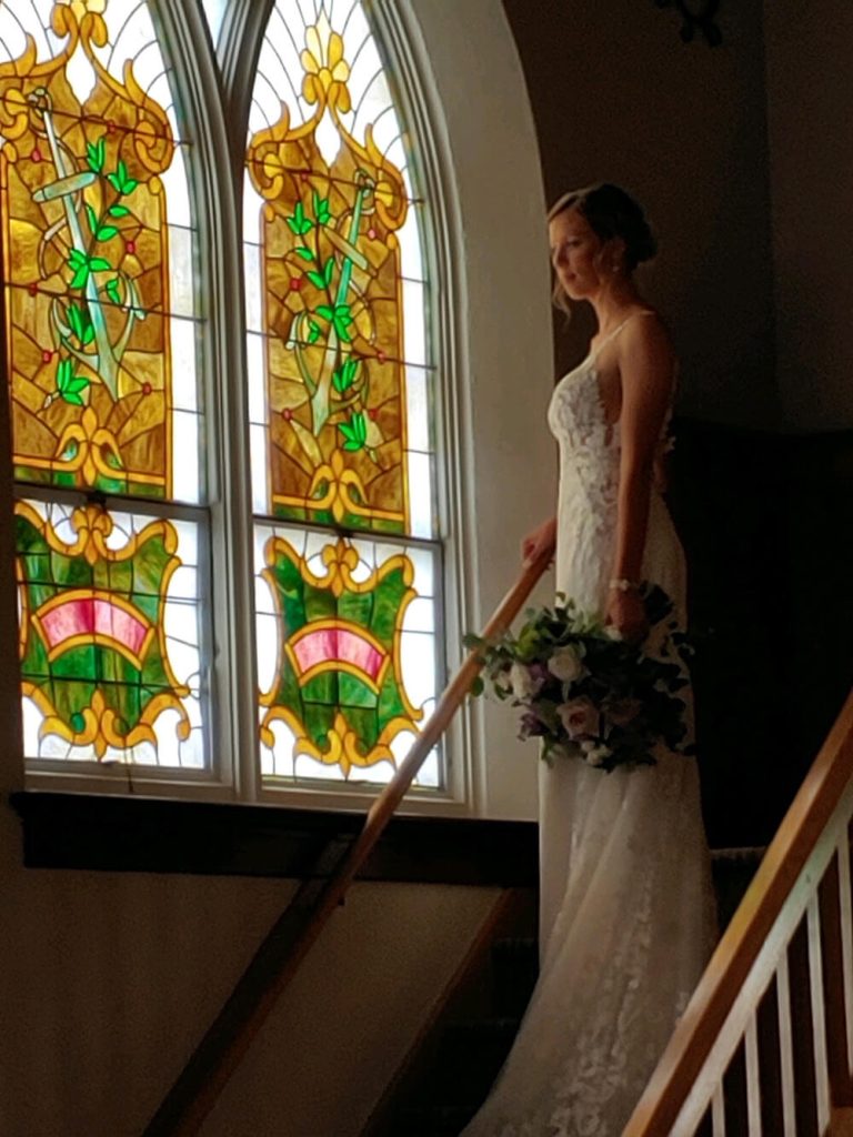 Bride looking out the window on her wedding day at the best Wedding Venue in Green Bay