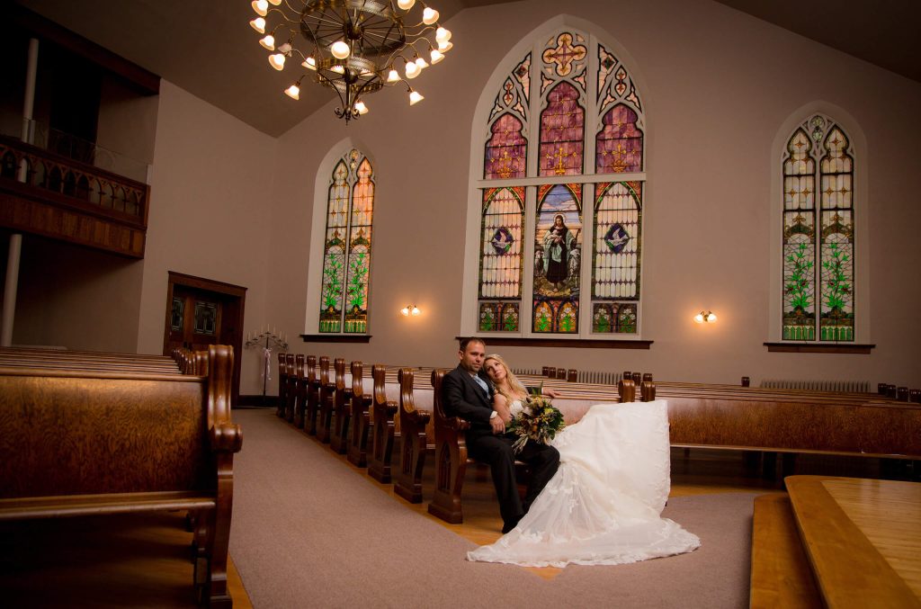 bride and groom sitting in pew