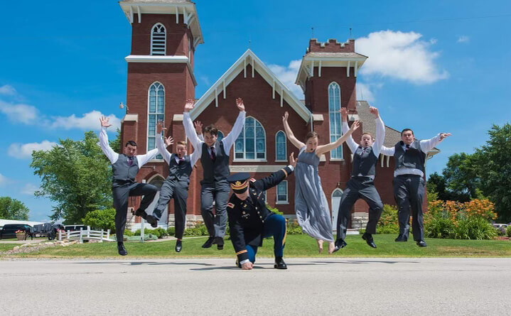 people jumping outside of wedding chapel