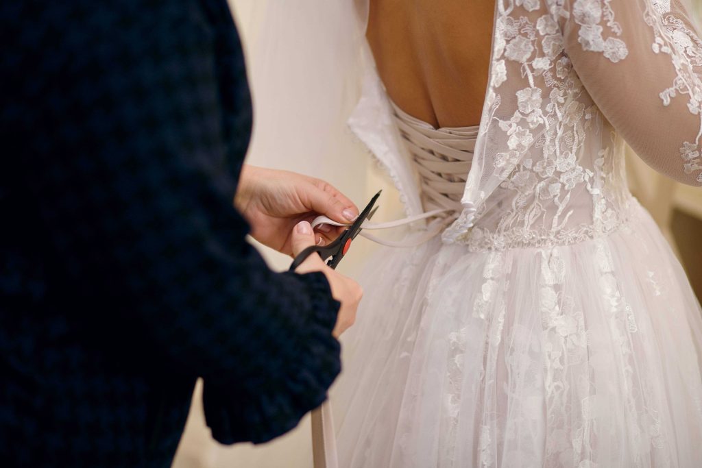 Groom cutting bride's wedding dress